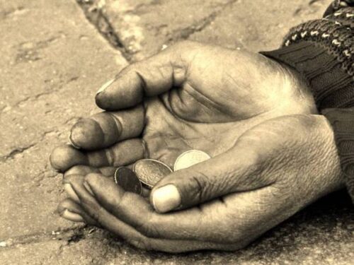 Maos com moedas esmola